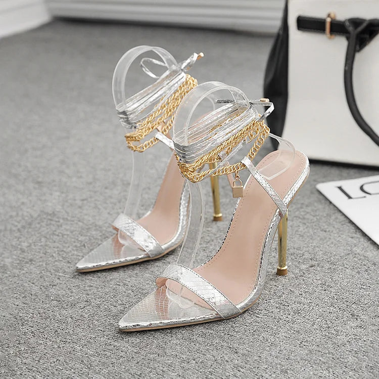 Scarpe con tacco a spillo a punta con lacci incrociati e decorazioni in metallo lucido