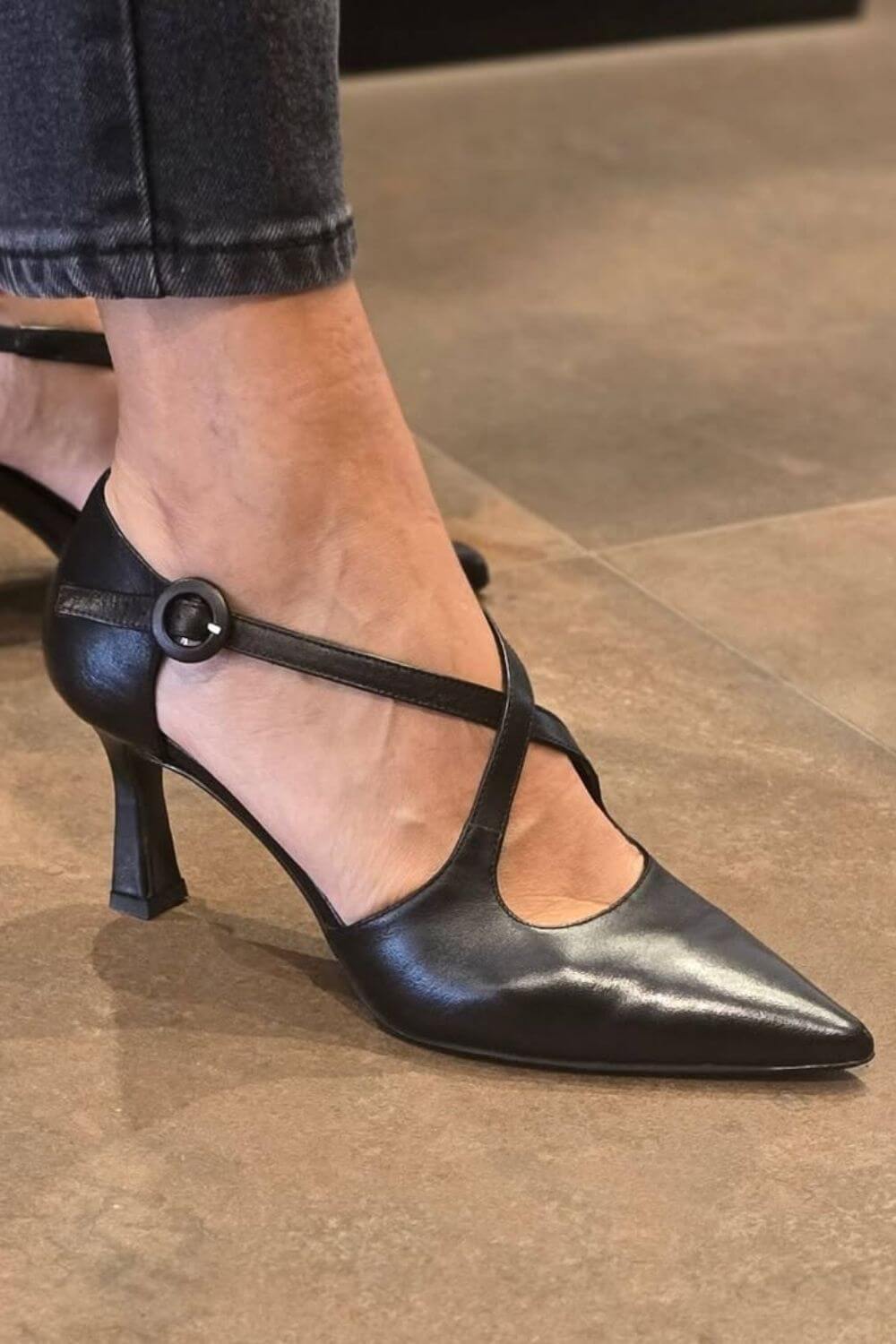 Schwarze Leder Spitz zulaufende Pumps mit Kreuzriemen und Stilettoabsatz
