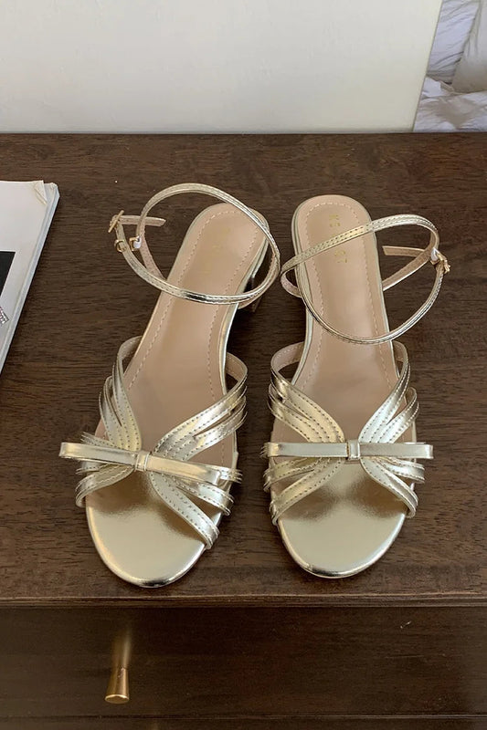 Sandali con cinturino alla caviglia, punta aperta, fibbia e tacco a spillo decorati con fiocco