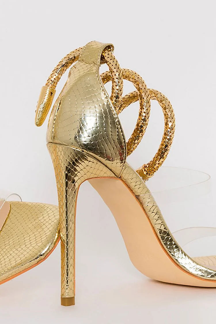 Sandalias de tacón de aguja con tiras transparentes en el tobillo y diseño de serpiente en dorado claro 