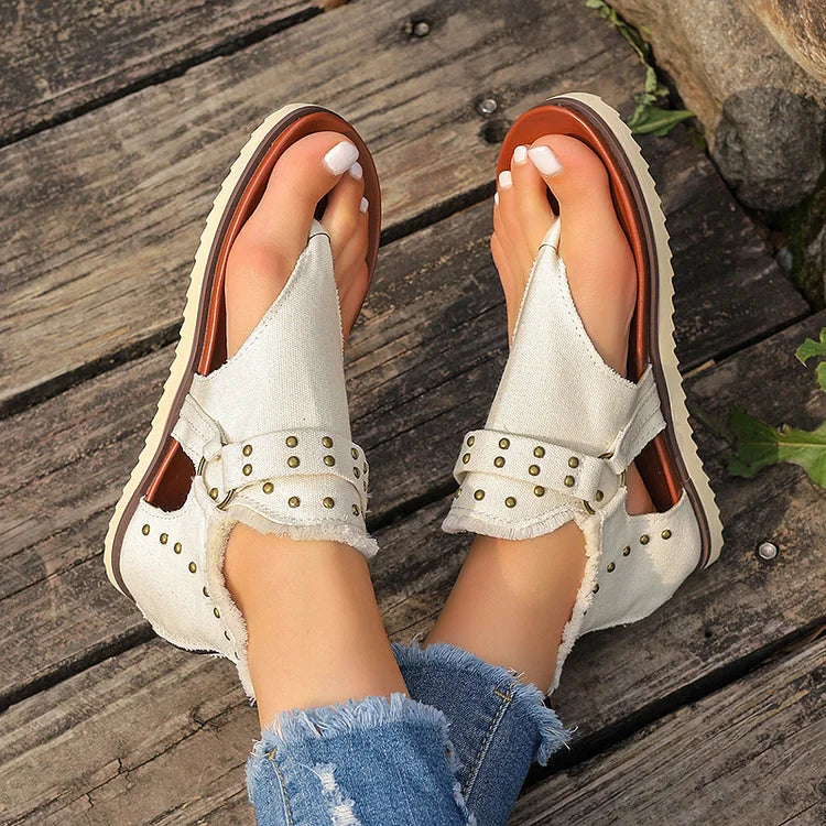 Sandalias tipo chanclas con costura con ribete sin rematar y decoración con tachuelas y hebilla con anilla en forma de O 