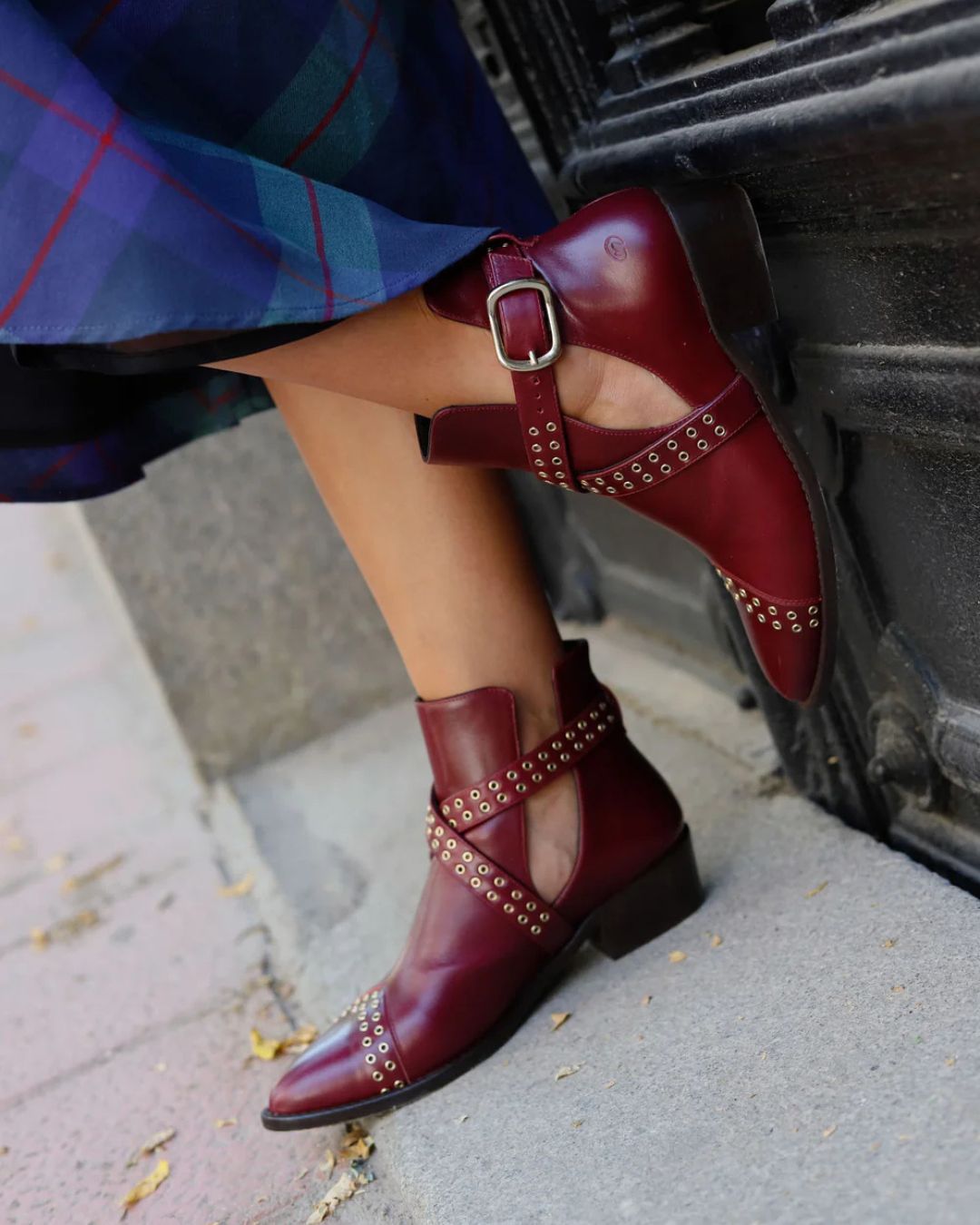 Stivaletti alla caviglia bordeaux con borchie, cinturino incrociato, punta a punta e cut-out