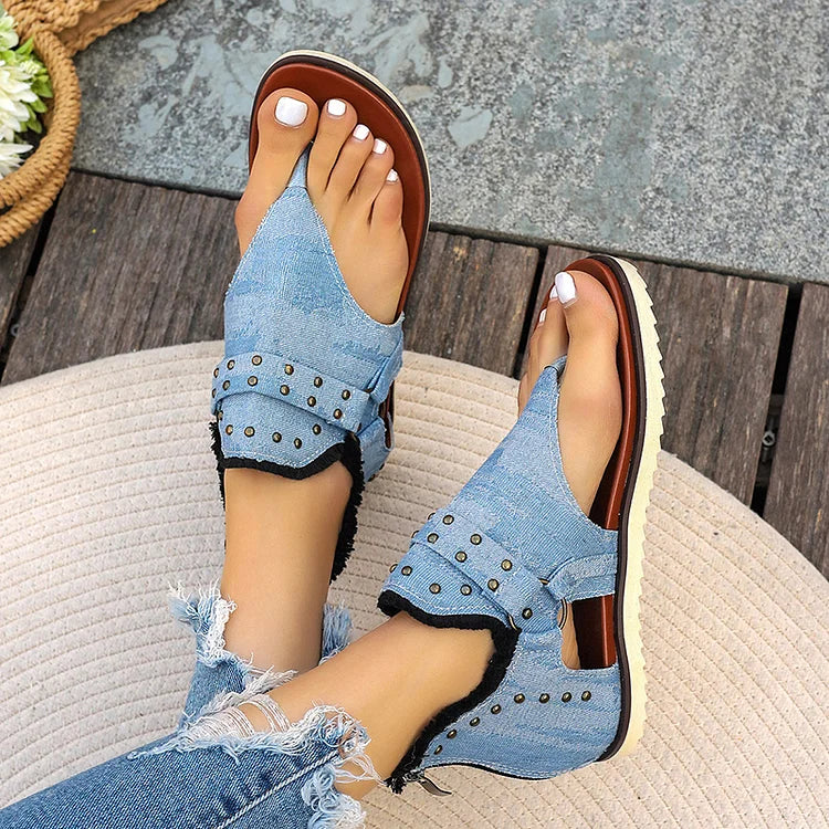 Sandalias tipo chanclas con costura con ribete sin rematar y decoración con tachuelas y hebilla con anilla en forma de O 