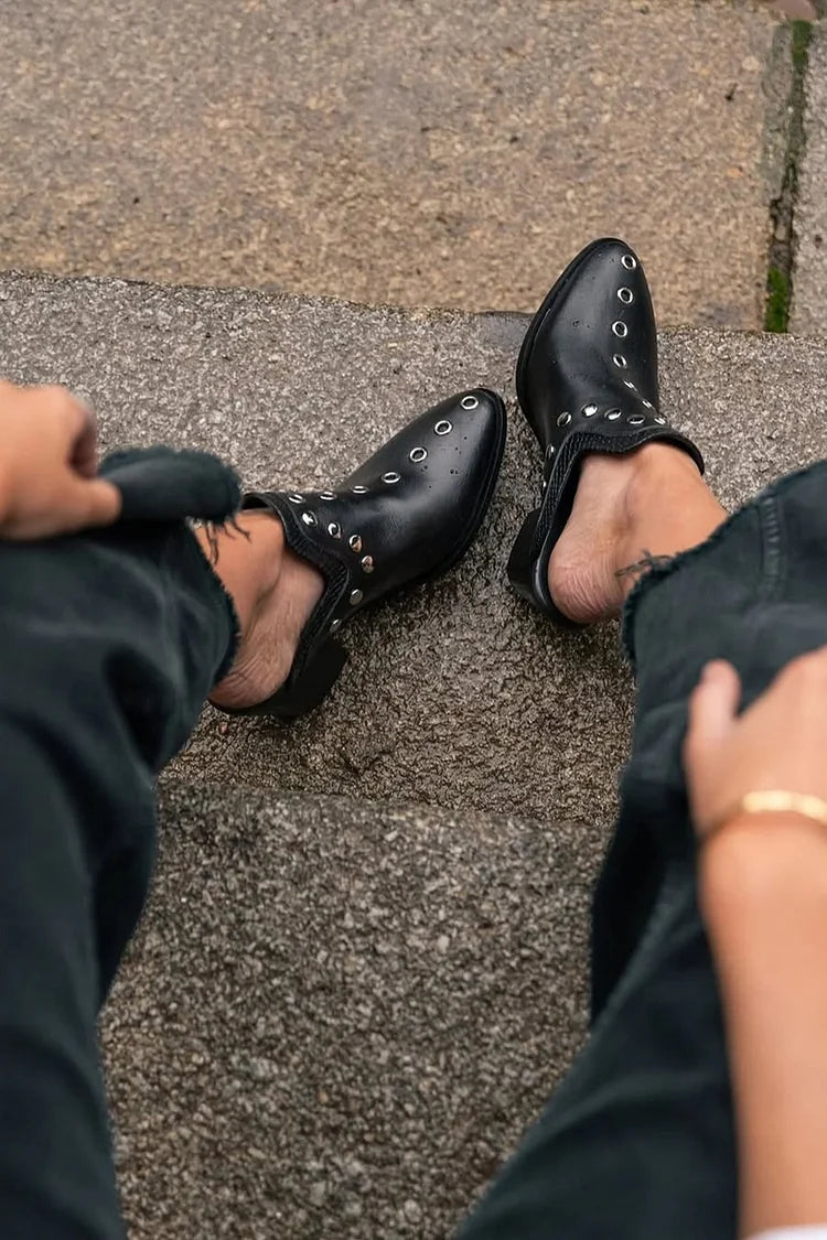Mules nere con tacco a spillo e decoro con occhielli metallici [Pre-ordine]