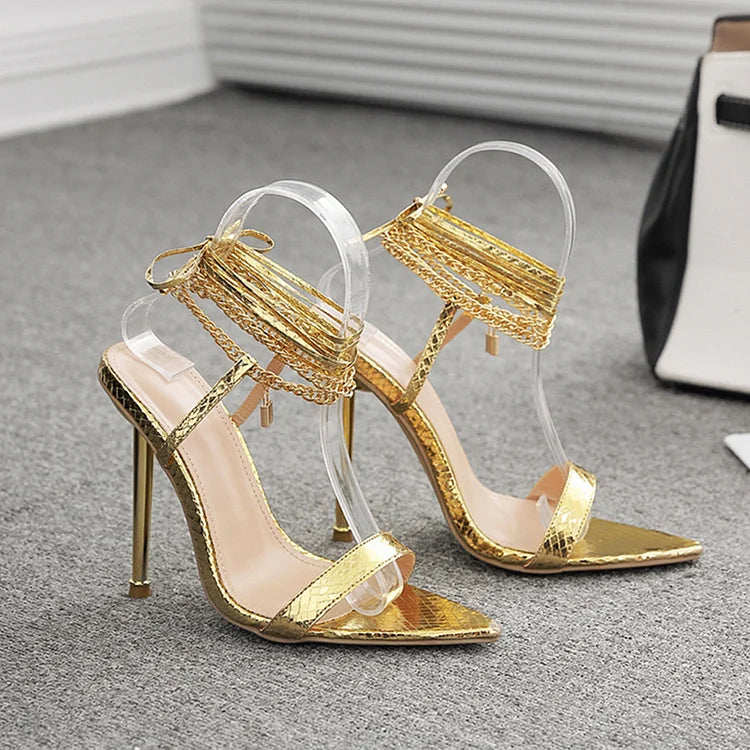 Scarpe con tacco a spillo a punta con lacci incrociati e decorazioni in metallo lucido