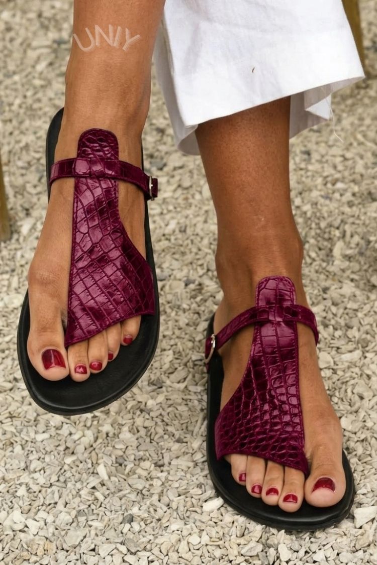 Flip-flops med spænde og krokodillepræget rem over vristen