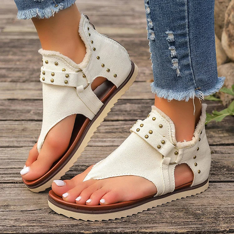 Sandalias tipo chanclas con costura con ribete sin rematar y decoración con tachuelas y hebilla con anilla en forma de O 