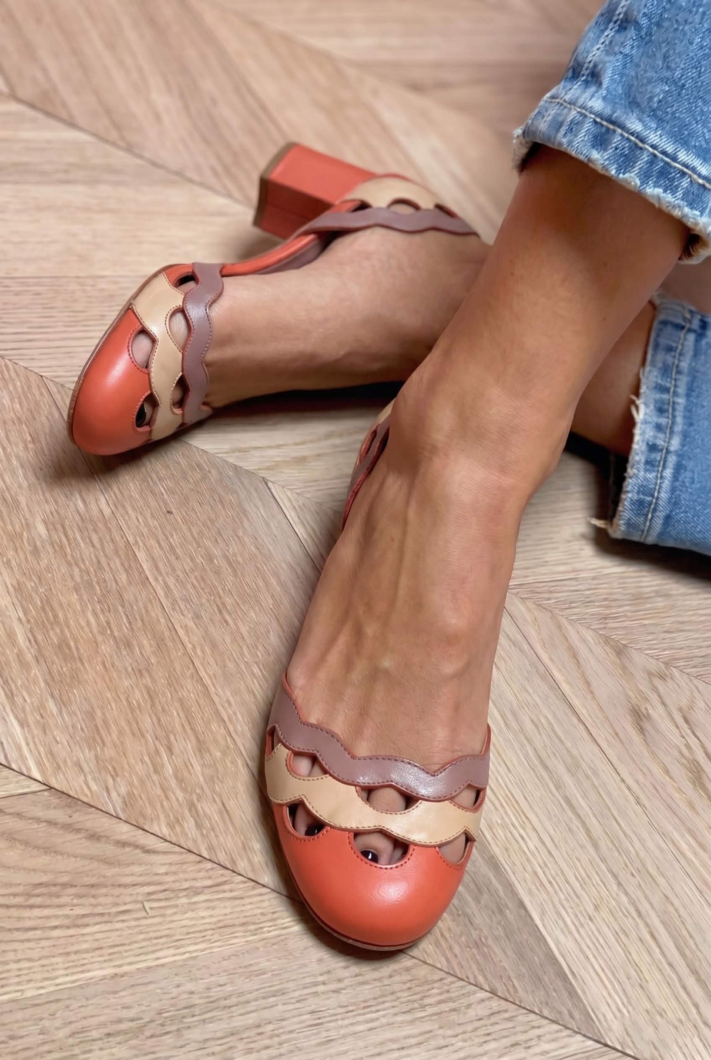 Slingback met geschulpte uitsnijding, kleurvlakken en dikke hakken in koraal [Pre-order]
